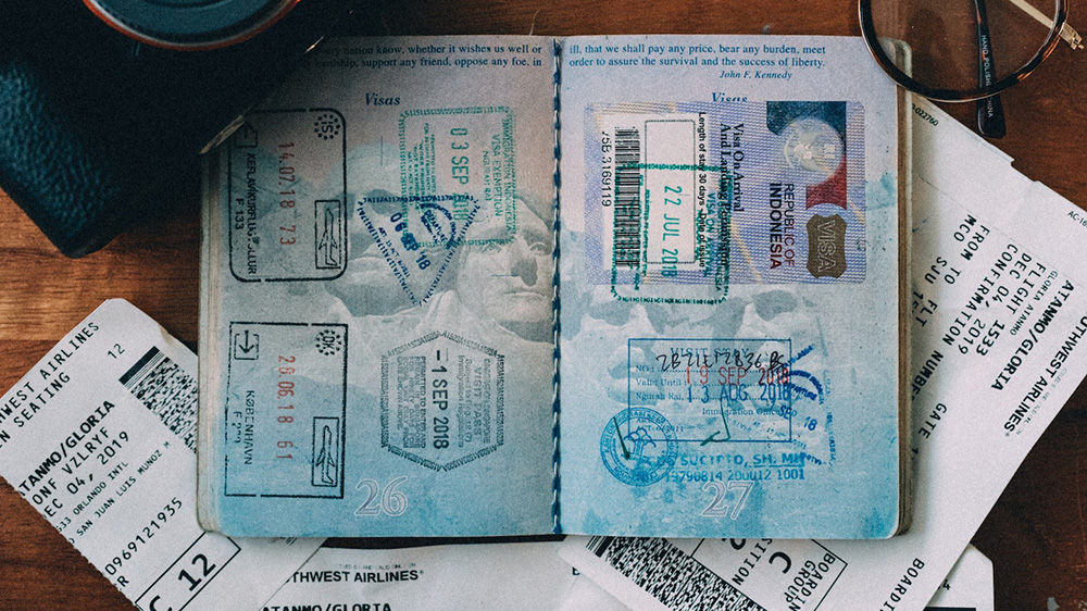 A passport book open with stamps from traveling.